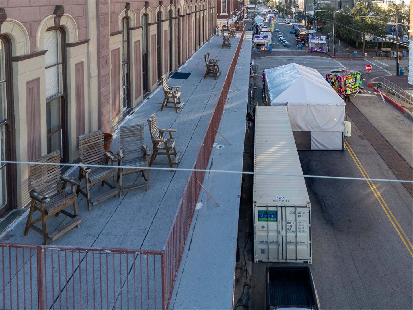 Close up aerial view of your shared balcony, vendors below setting up for Mardi Gras.