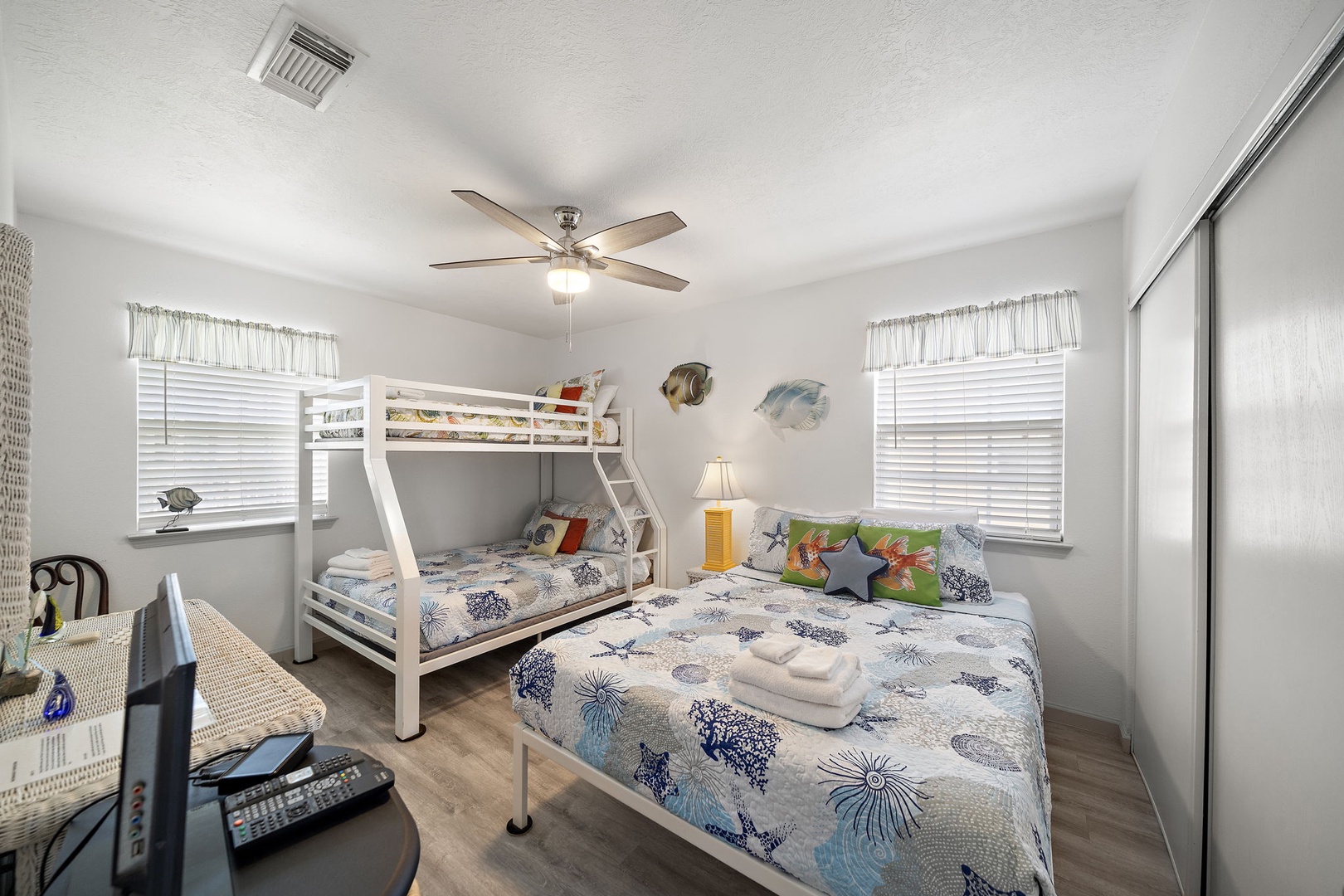 Your family will love this bright, ocean-themed bedroom off the living room with comfortable bunk beds and a queen bed - perfect for creating lasting vacation memories together while you enjoy the coastal decor and airy atmosphere.