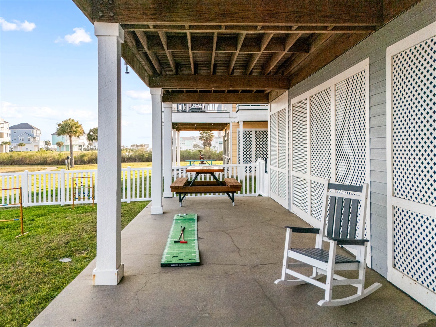 Covered patio with picnic table and rocking chair.
