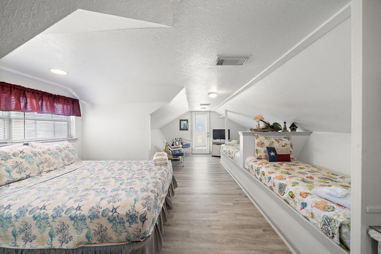 Your cozy attic retreat offers the perfect hideaway with built-in beds that make you feel like you're sleeping in a charming tree house, complete with fresh linens and warm natural light streaming through the windows.