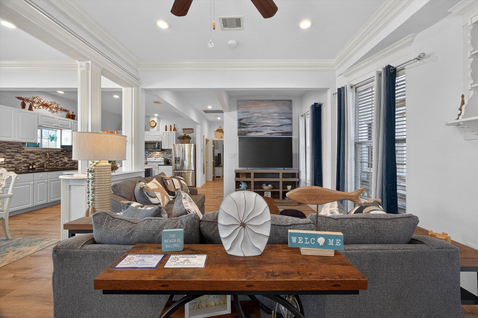 Sink into plush coastal comfort in your open-concept living space, where vaulted ceilings and beach-inspired decor create the perfect retreat.