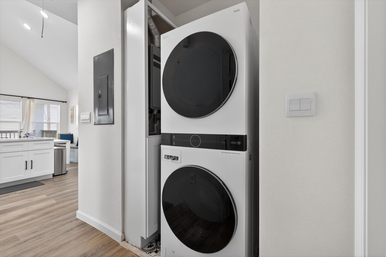 Stacked washer and dryer in hallway closet.