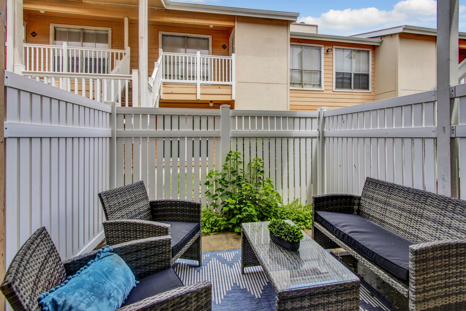 Fenced patio with comfortable seating and charm.