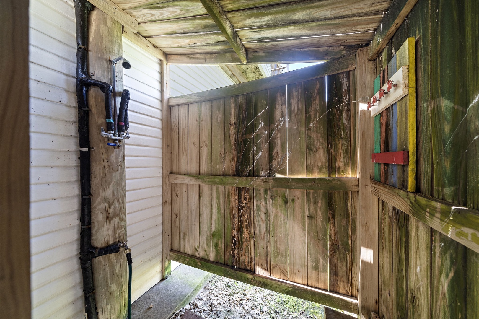 Step into your private rustic outdoor shower, where weathered wood walls and natural textures create an authentic retreat. Feel the fresh air as you rinse away the day in this charming enclosed space.