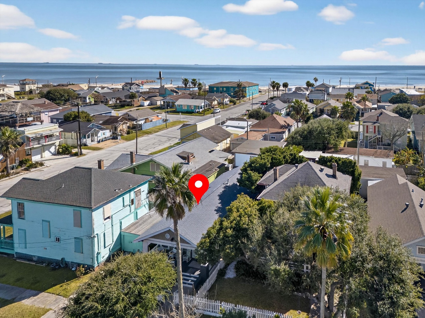 Aerial view of a charming coastal neighborhood with colorful beach houses and ocean proximity.
