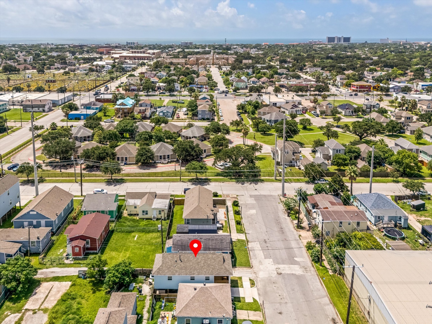 Aerial perspective of neighborhood under a bright summer sky.