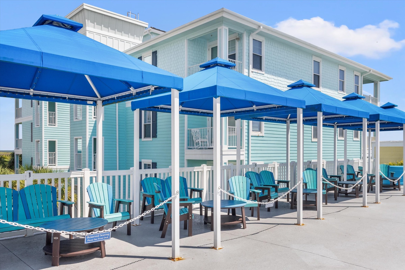 Beachfront property with turquoise chairs and coastal style.