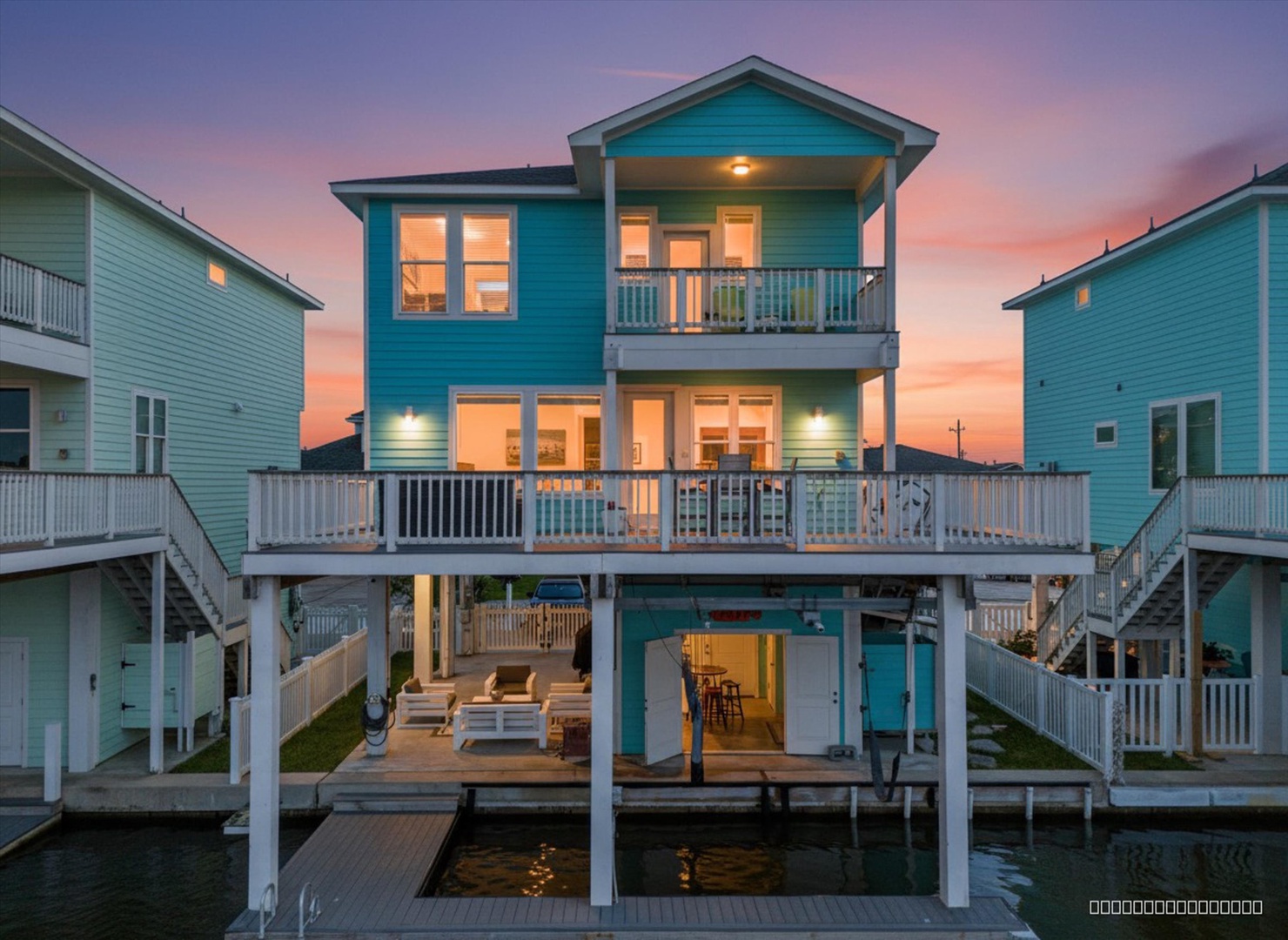 A stunning waterfront property glows warmly in the sunset