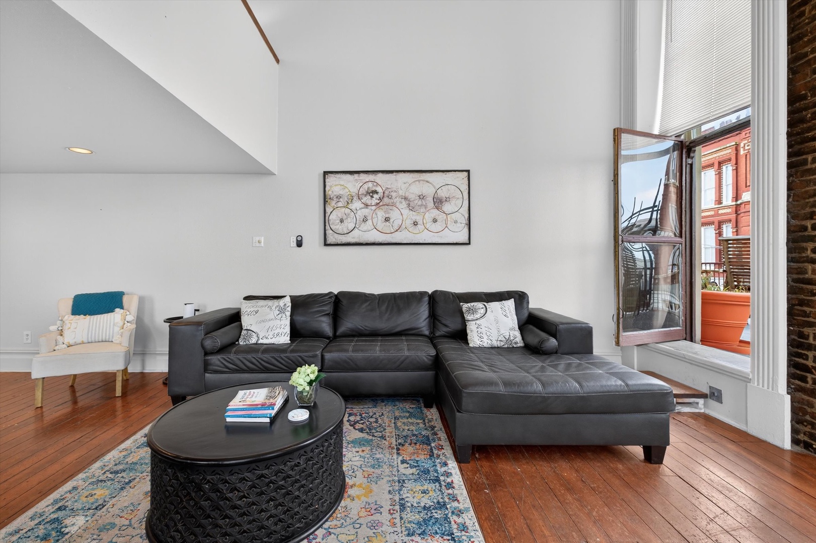 Spacious living room with sectional and vaulted ceilings. Step through the window to the balcony
