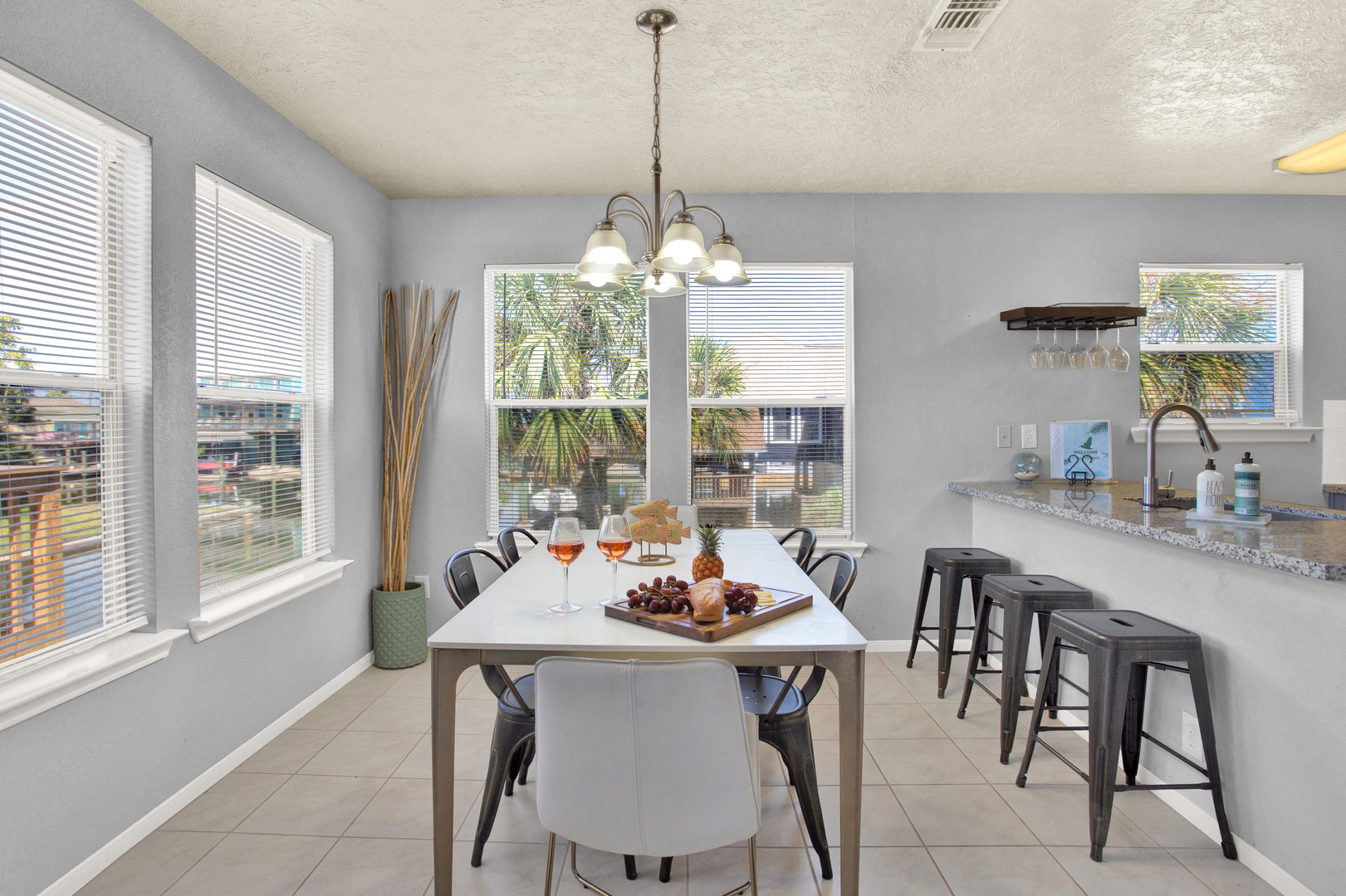 Step into your bright, open dining space where natural light pours through multiple windows. Gather around the modern table for meals and conversation, or pull up a seat at the sleek breakfast bar with a morning coffee in hand.