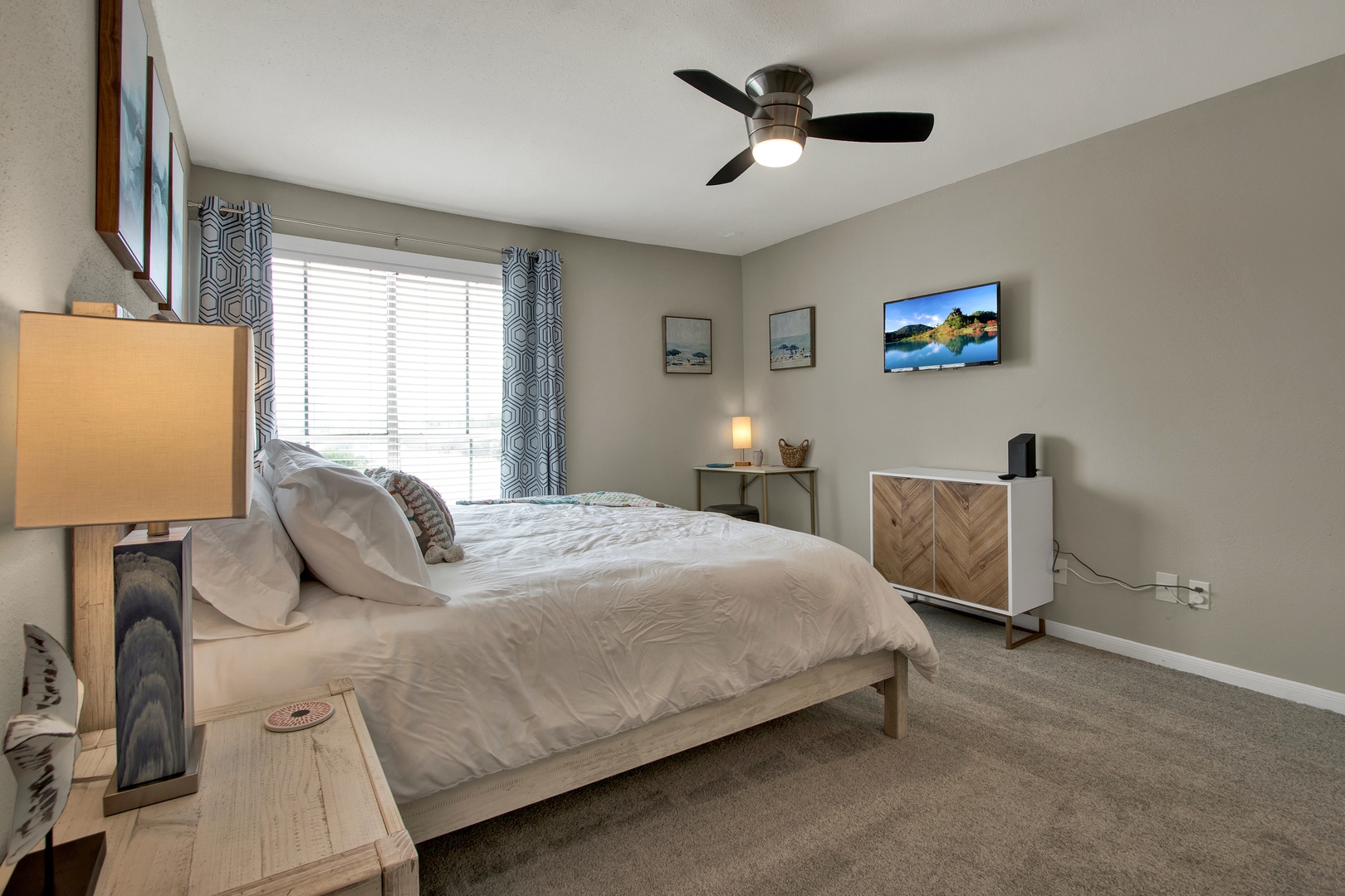 Peaceful bedroom with soft linens and ceiling fan.