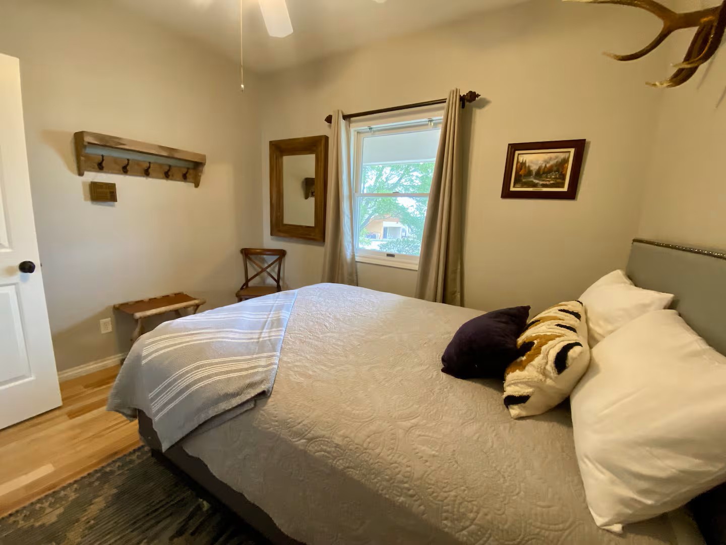 Step into your cozy retreat—a comfortable bed awaits beneath rustic charm. Your peaceful escape.