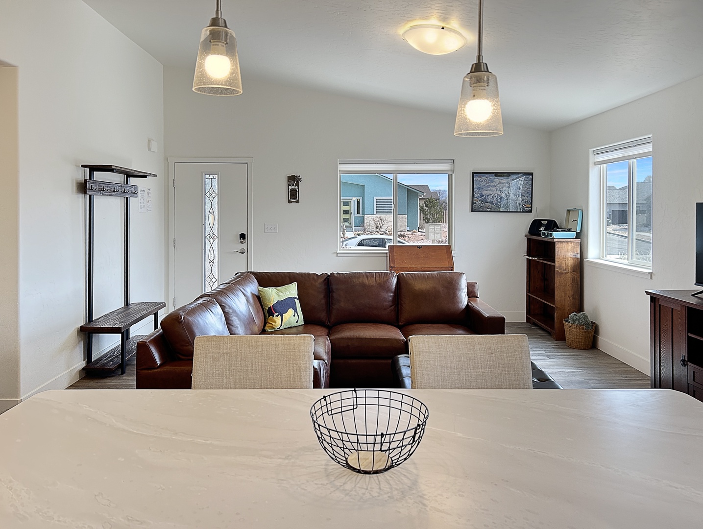 Sink into the plush leather sectional as natural light streams through large windows, creating your perfect retreat for relaxation and connection.