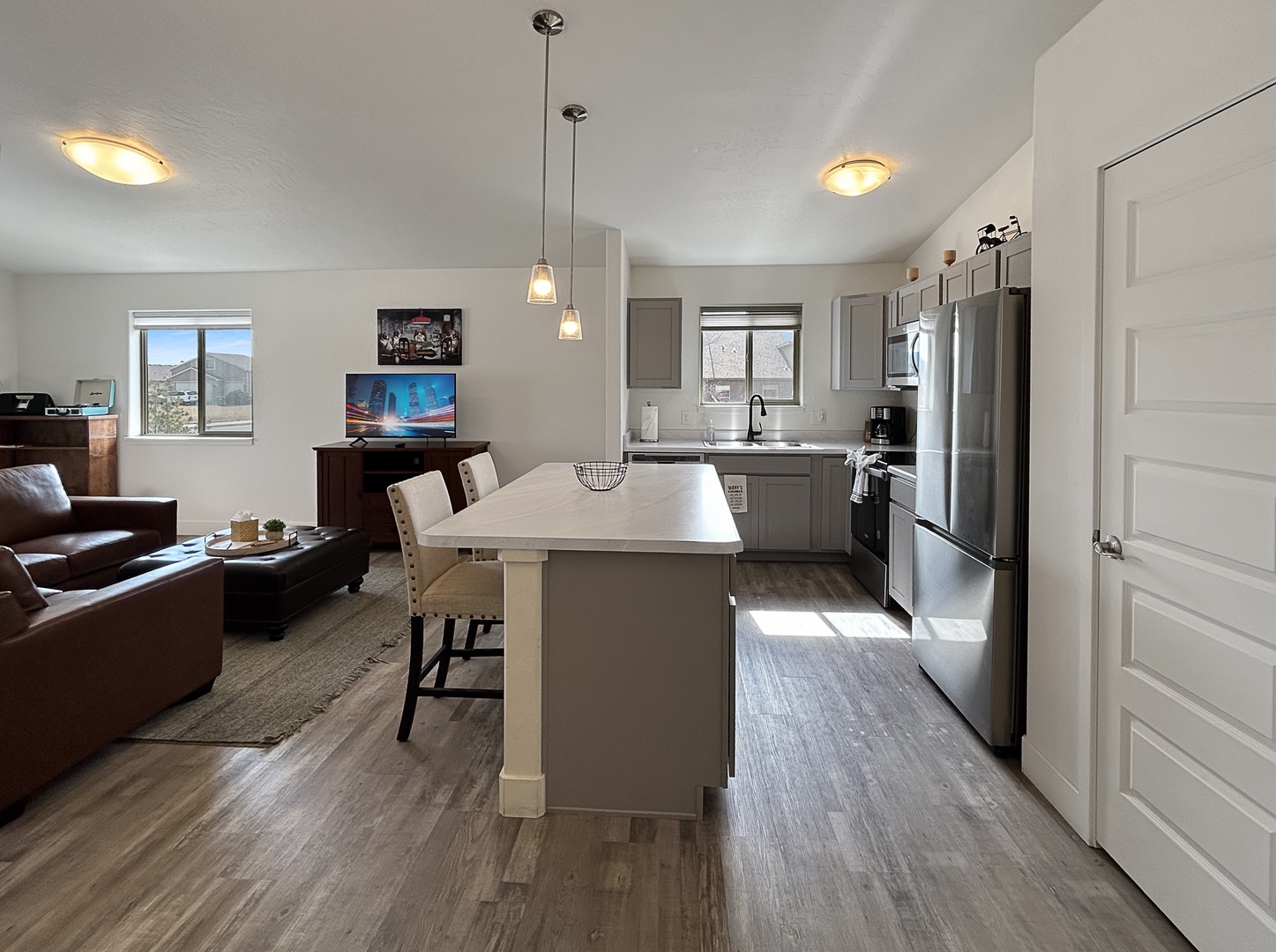 Your modern open-concept space flows from kitchen to living room, perfect for cooking and relaxing with mountain views streaming through large windows.