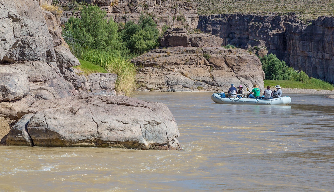 River rafting adventure through dramatic canyon landscape with towering rock formations and scenic wilderness.