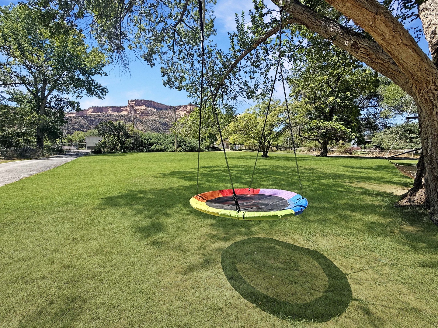 This spacious property is set on expansive grounds with sweeping lawn areas, mature shade trees, and a colorful swing for outdoor fun.