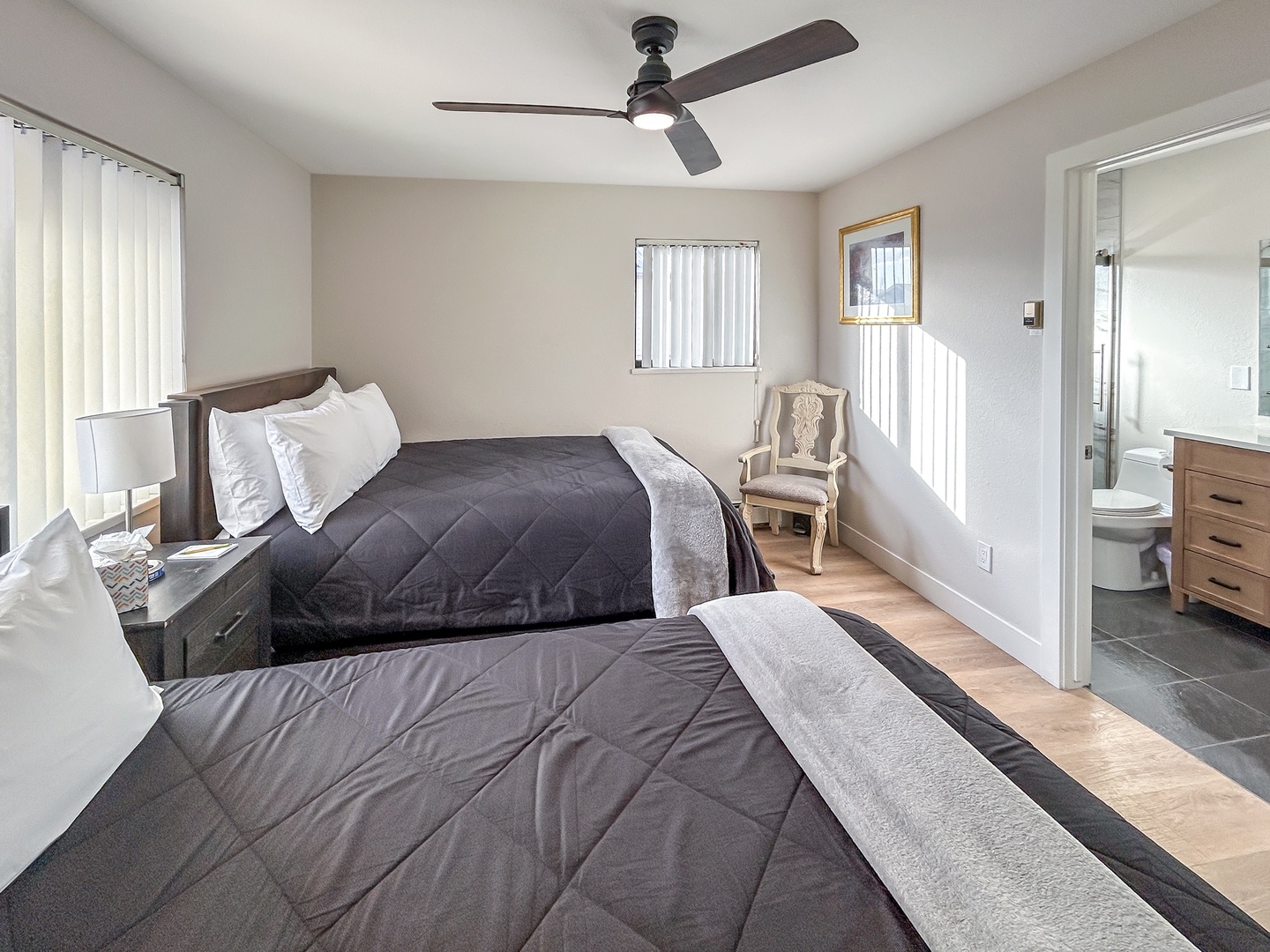 Your comfortable bedroom features two plush queen beds, a ceiling fan for gentle airflow, and an ensuite private bathroom.