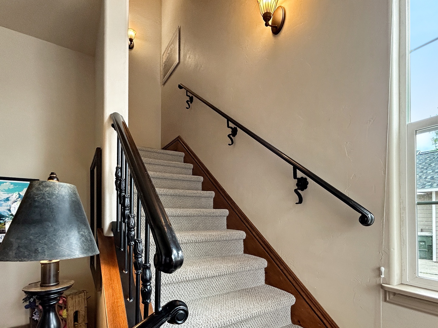 Elegant staircase welcomes you with warm lighting and classic railings, creating a grand entrance to your upper-level retreat.