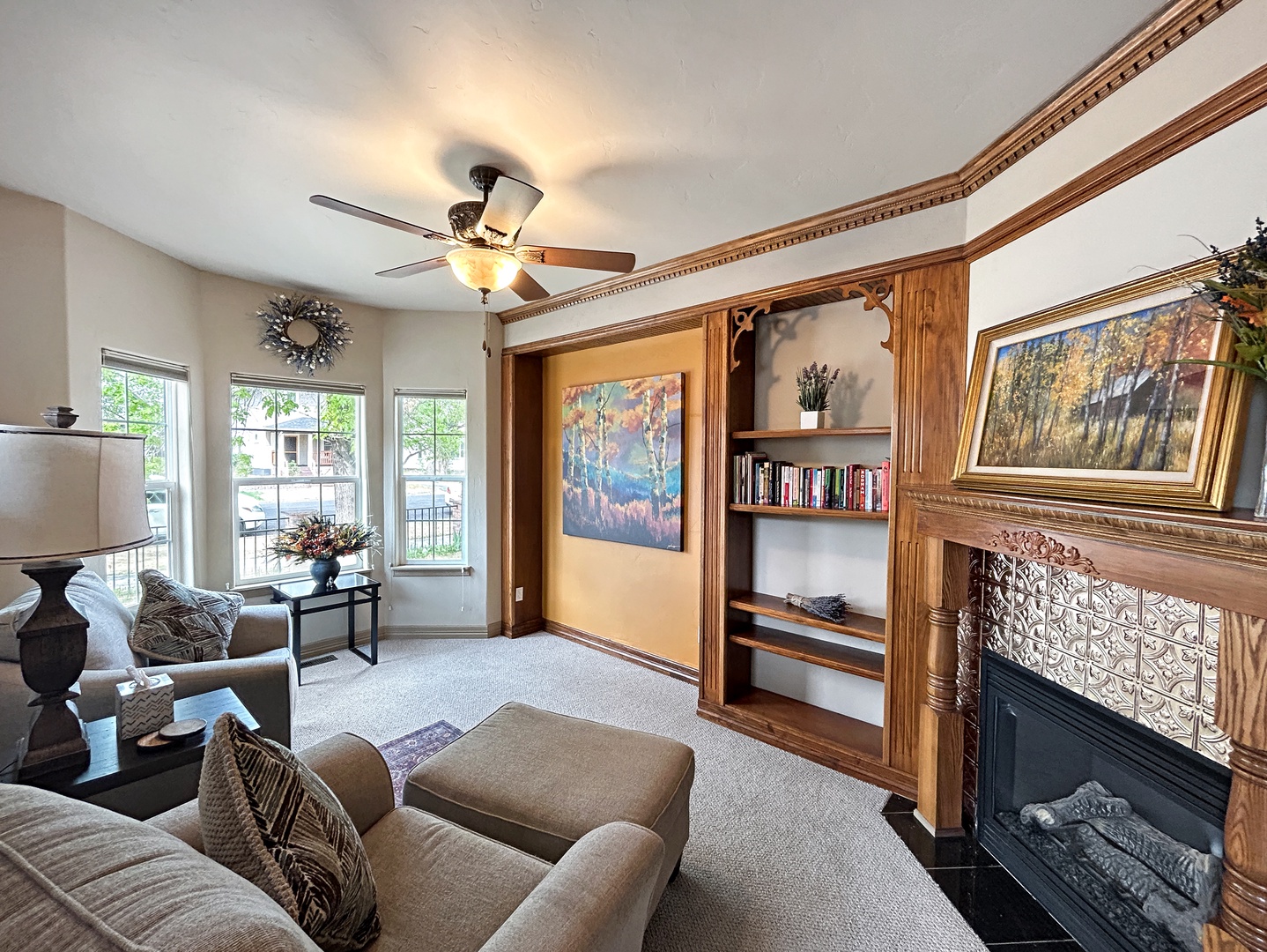 Parlor room with beautiful windows and natural light. Cozy up on one of these big comfy chairs and read a book from our selection of good reads.