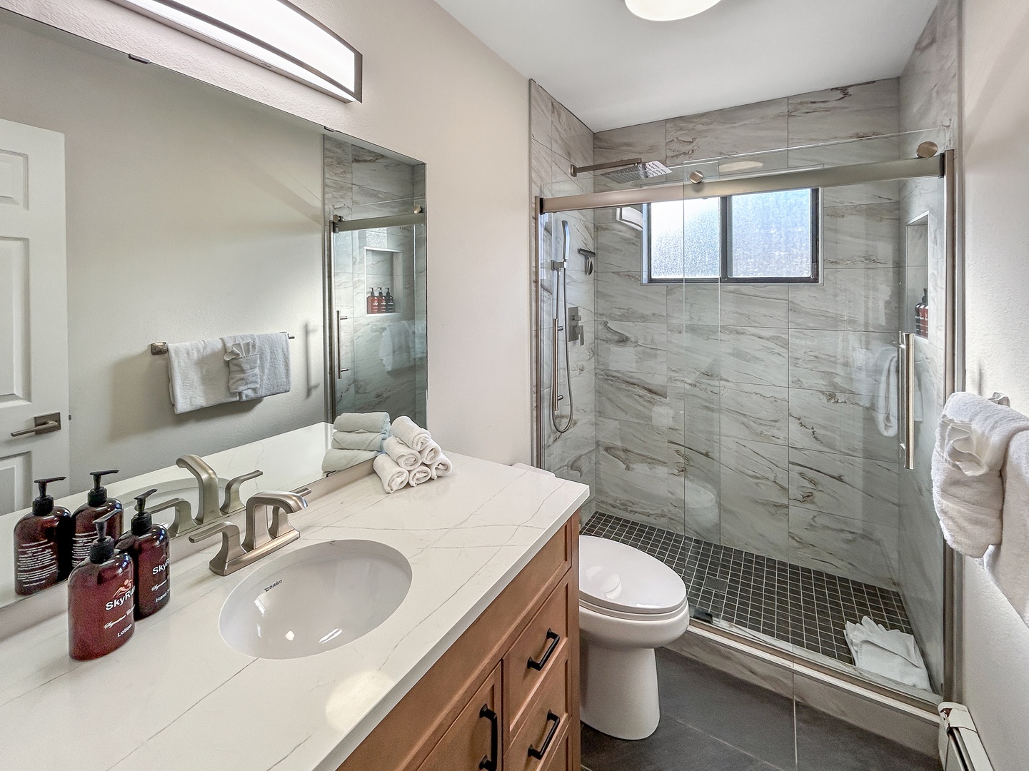 Spacious main bathroom with walk-in shower, plush towels, and luxury amenities for your ultimate relaxation.