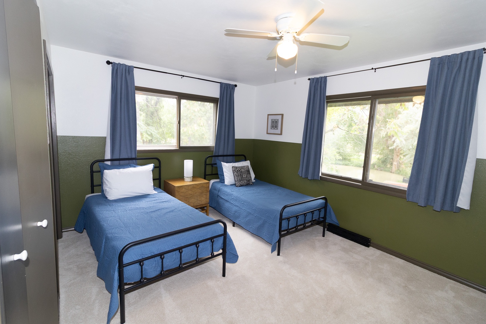 Unwind in your peaceful twin room with two comfortable beds, natural light from dual windows, and a ceiling fan to keep you cool and relaxed.