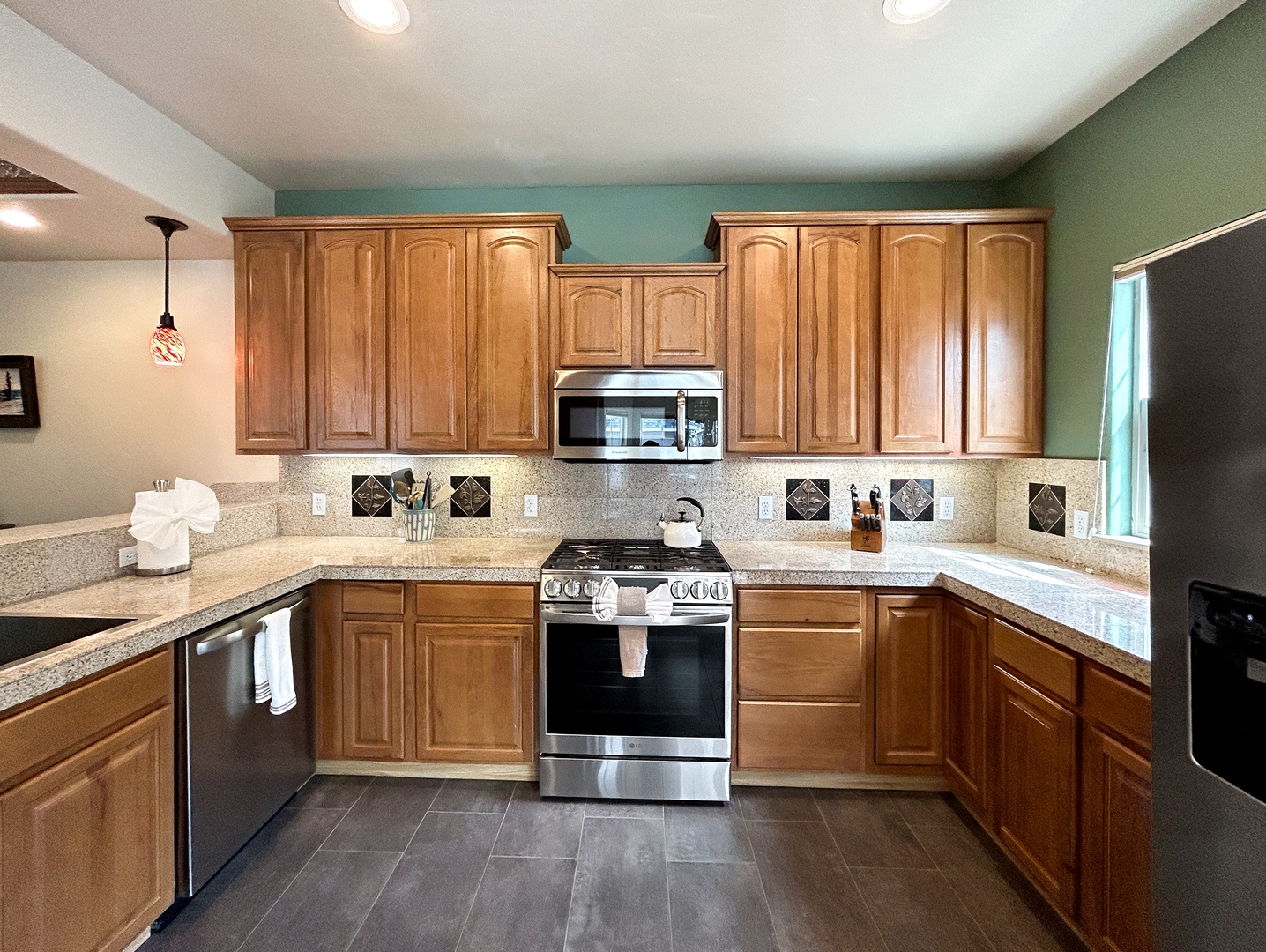 Your spacious kitchen features granite countertops, warm wood cabinets, and stainless steel appliances, perfect for cooking your favorite meals.