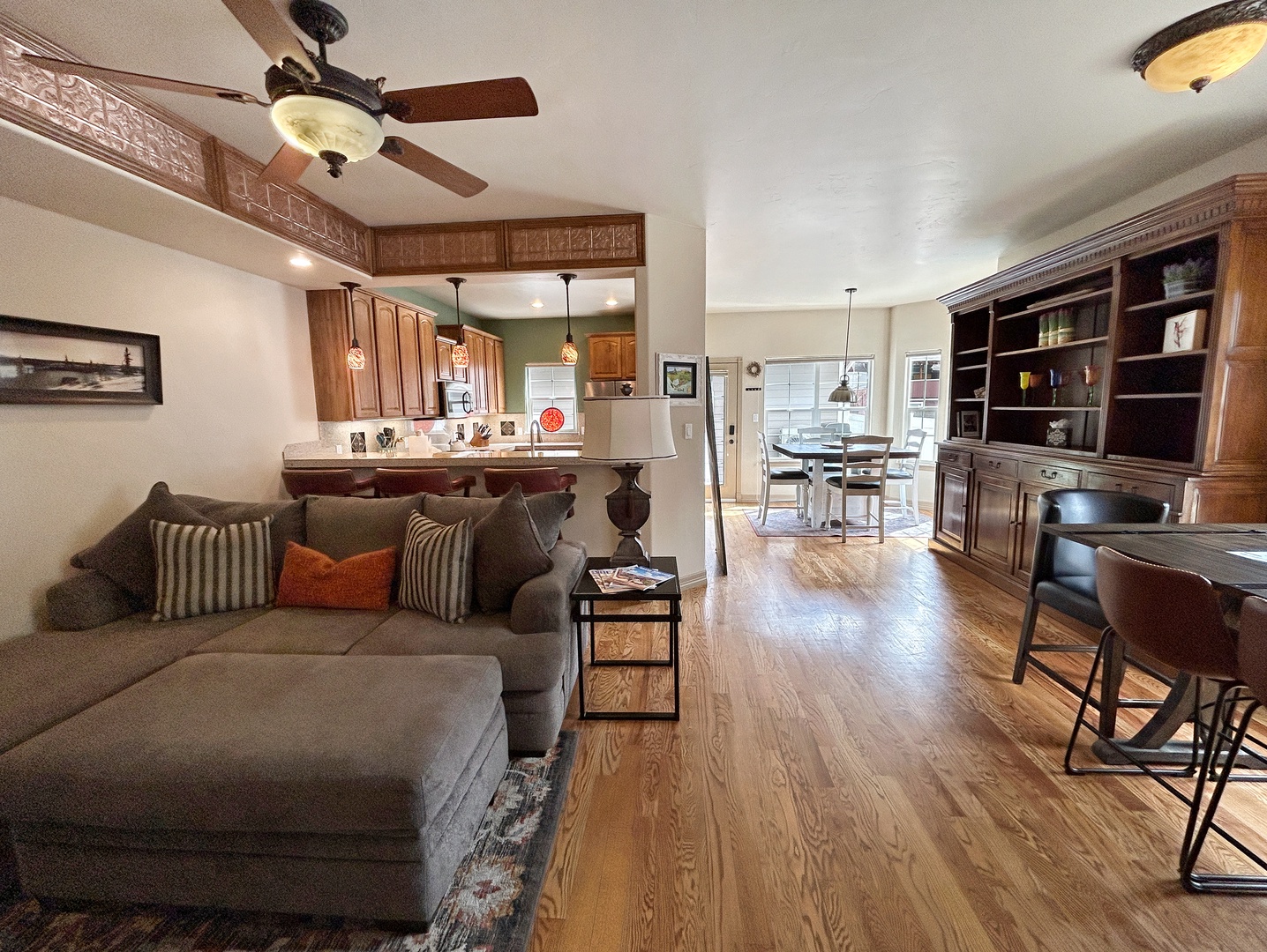 Relax in your spacious open-concept living area where warm wood floors flow from cozy seating to a fully equipped kitchen.