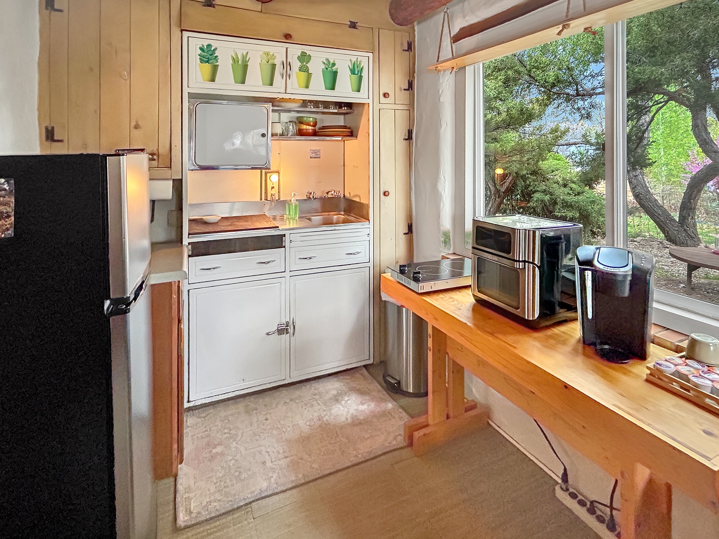 Your charming compact kitchen awaits with modern appliances and garden views for inspiring meal preparation.