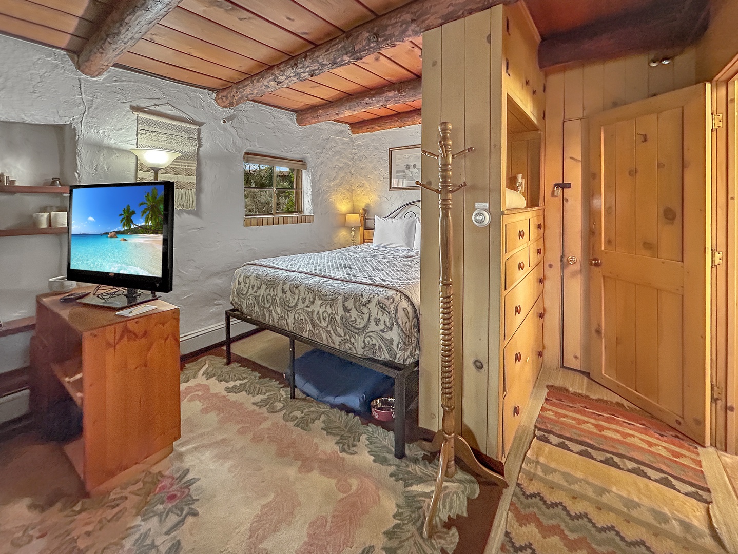 Unwind in your charming rustic bedroom with exposed beams, cozy furnishings, and modern amenities.