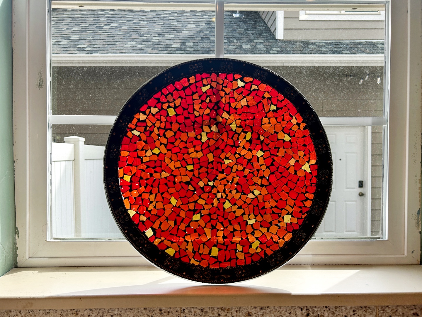 Admire this stunning handcrafted mosaic art piece, perfectly positioned to catch natural light streaming through your window.