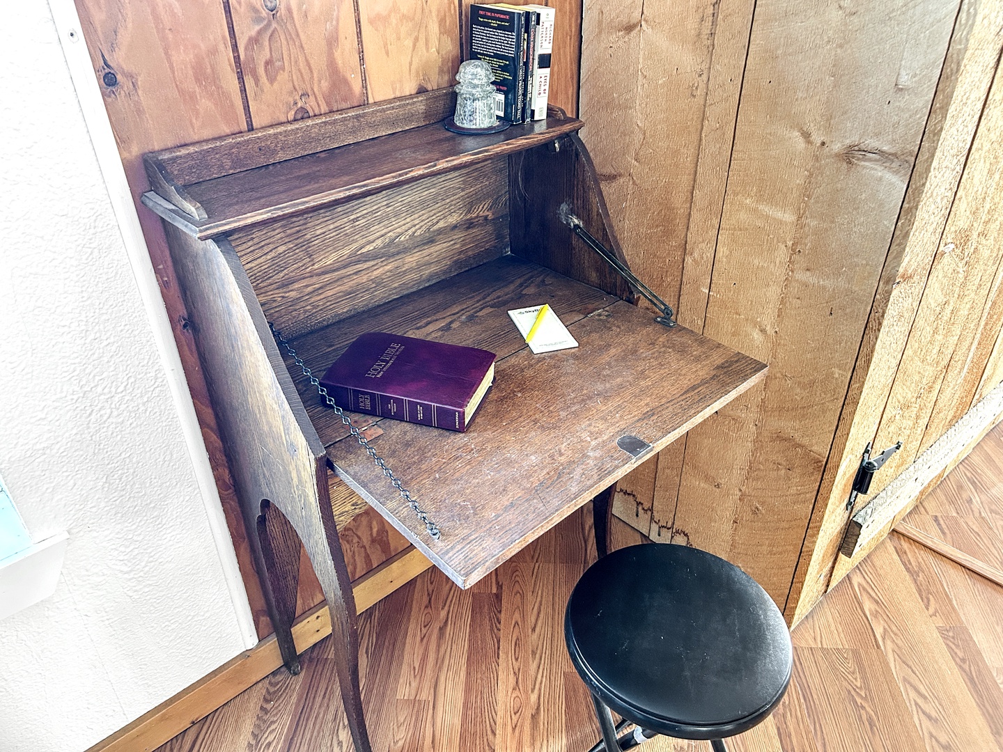 Your private writing nook awaits with vintage charm—fold-down desk, cozy stool, and rustic wood walls create the perfect spot for journaling.