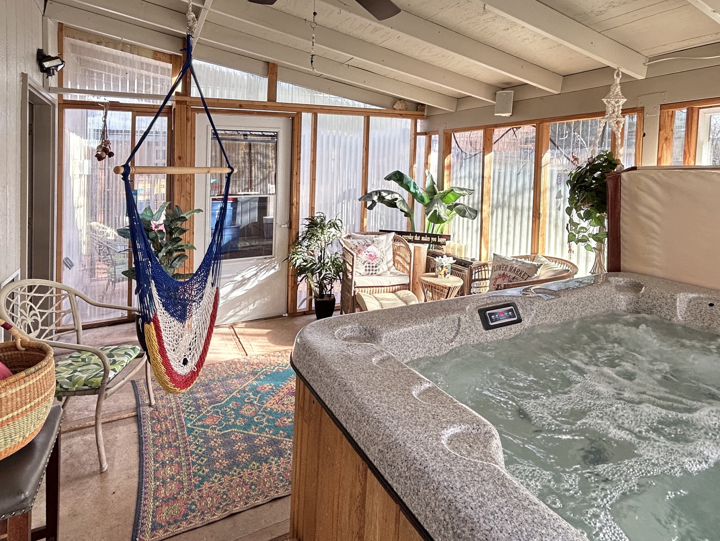 Private hot tub with sunlight, hammock, and lush indoor oasis.
