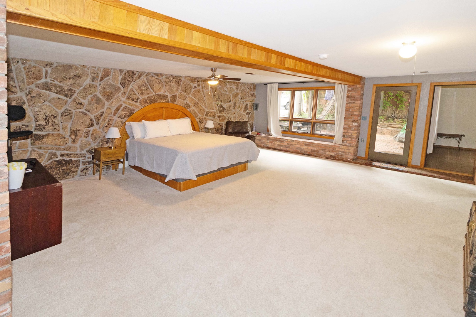 Sink into the plush king bed in your spacious suite, where rustic stone walls and warm wood beams create a charming, peaceful retreat.