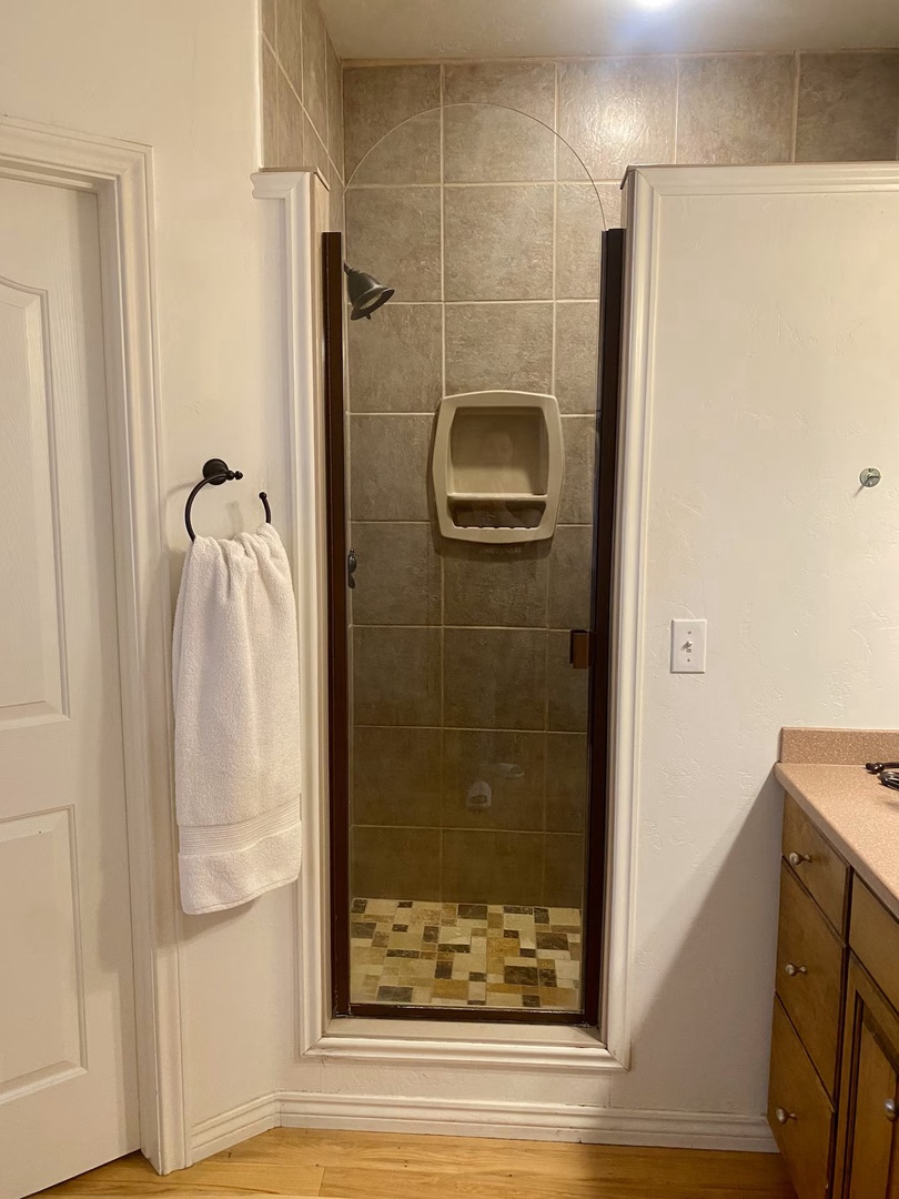 Step into your private shower with its built-in niche and sleek tile surround.