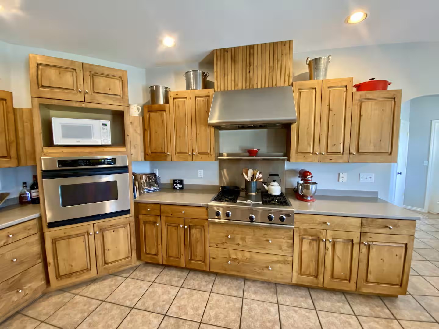 Fully equipped kitchen features warm wood cabinetry and stainless steel appliances.