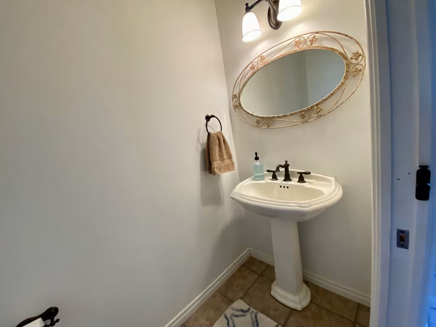 Freshen up in your private powder room—a charming space with elegant details, soft lighting, and pedestal sink.