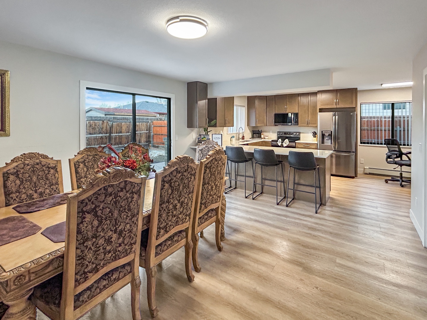 Step into your spacious open-plan living space with modern kitchen island seating, and bright windows framing peaceful neighborhood views.