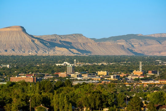 Dramatic mesa formations create a striking backdrop to the local town below, showcasing the area's unique natural beauty.