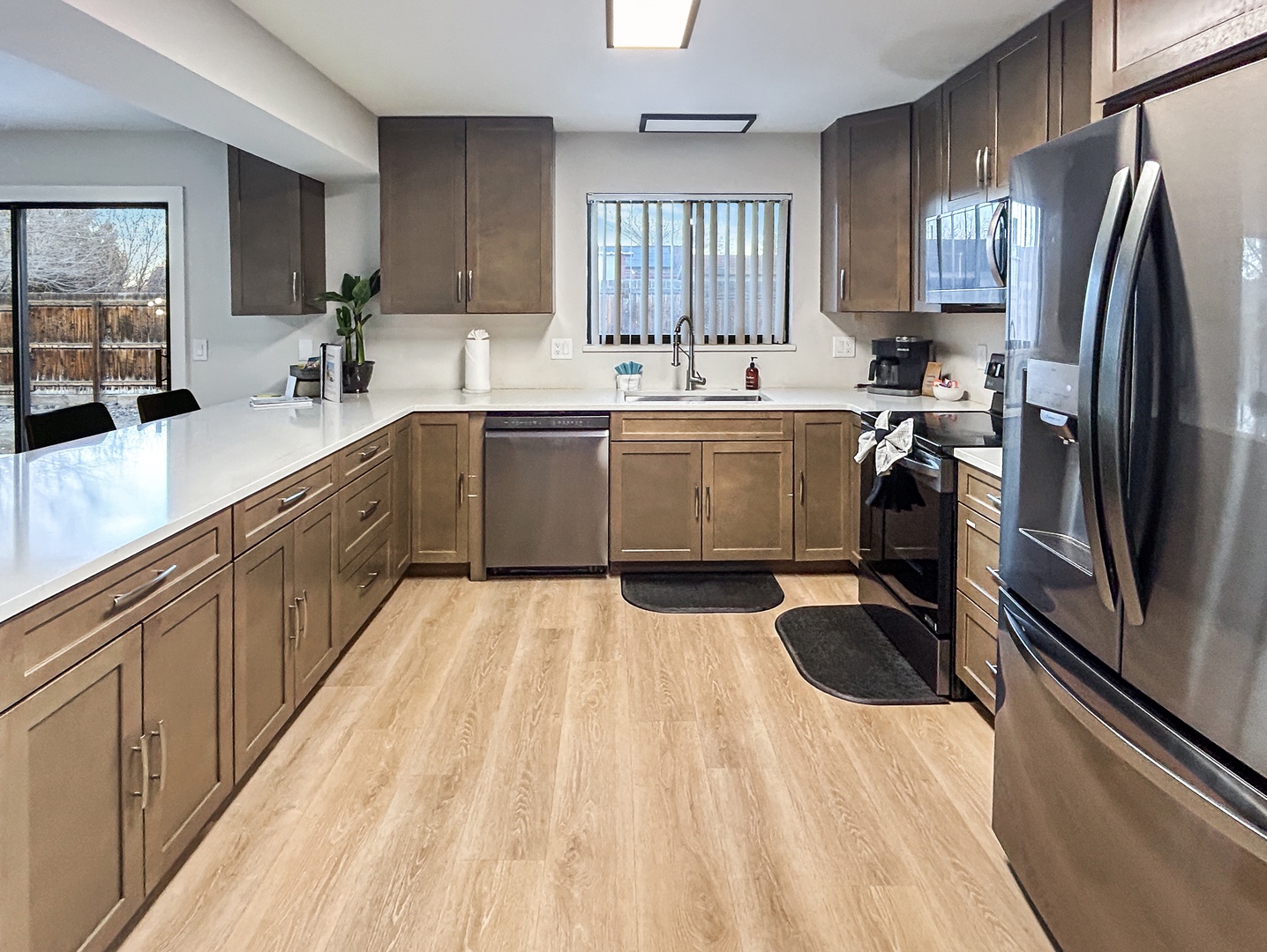 Spacious modern kitchen with gleaming countertops, bright and stainless appliances.