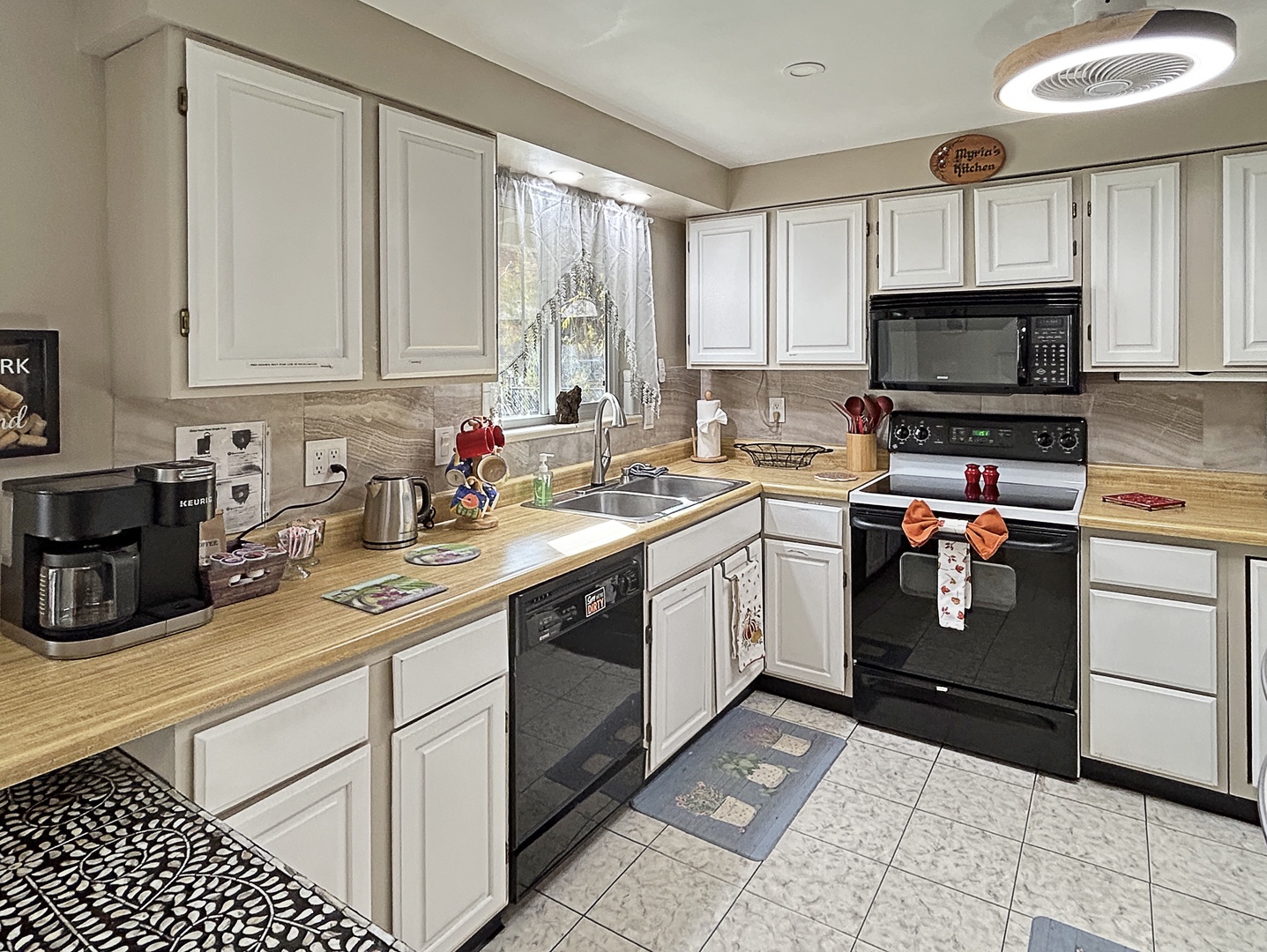 Kitchen with modern appliances, spacious counters, and cozy bar.