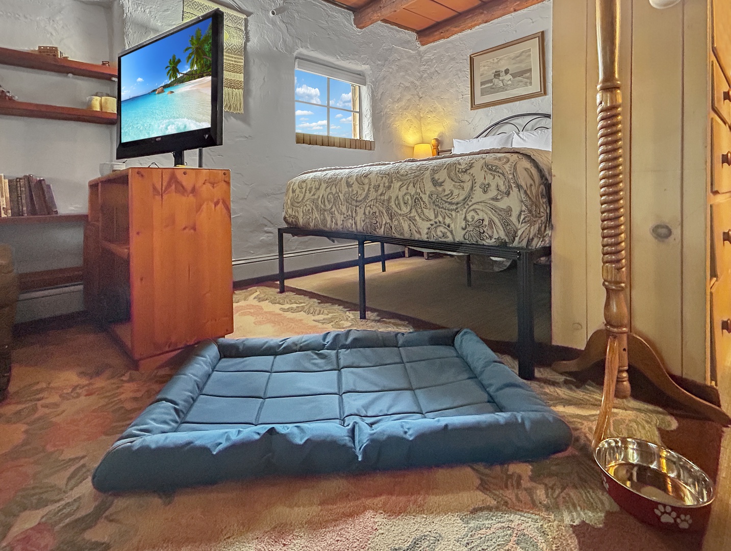 Your cozy bedroom features rustic charm with exposed beams, built-in shelving, and comfortable sleeping spaces for both you and your furry companion.