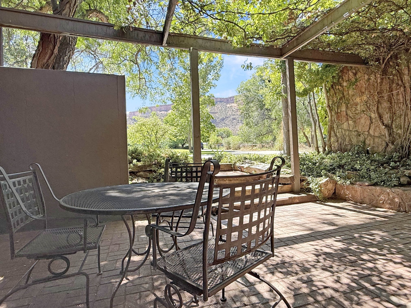 This shaded outdoor dining space invites you to enjoy peaceful mornings and scenic sunsets surrounded by natural beauty.