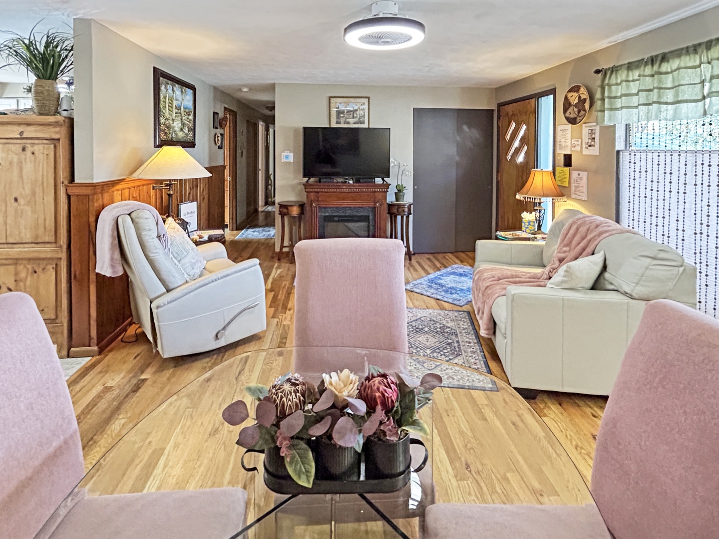 Cozy living space with warm woods, soft pinks, and plush seating.