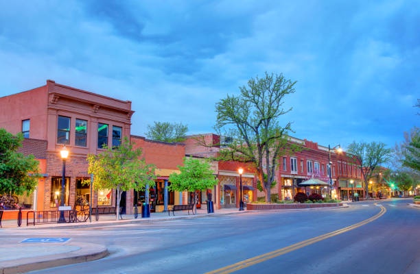 Historic downtown street featuring charming brick buildings with shops and restaurants under a beautiful evening sky.
