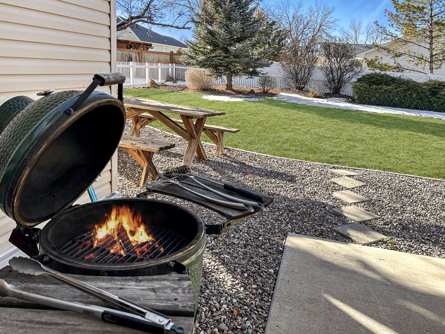 Enjoy this Green Egg charcoal grill and spacious backyard