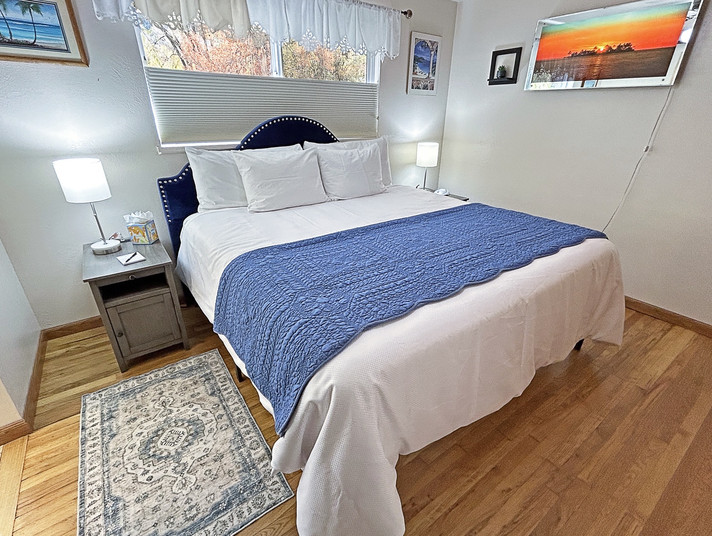 Bedroom retreat with crisp linens, blue accents, and sunlight.