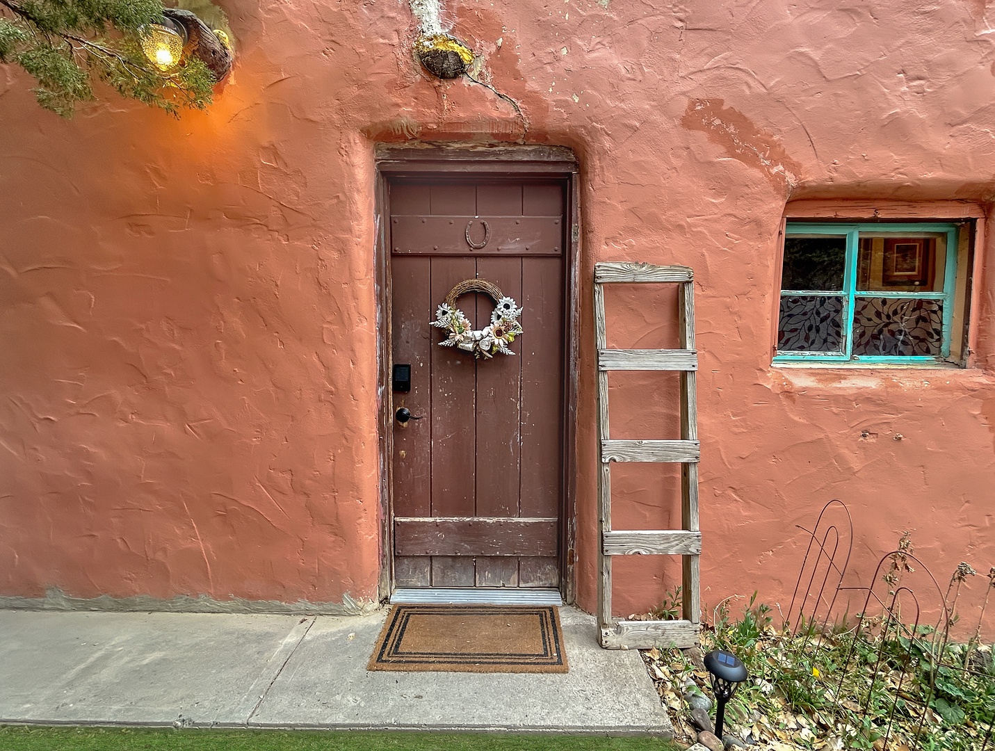 Charming adobe entrance with rustic wooden door.