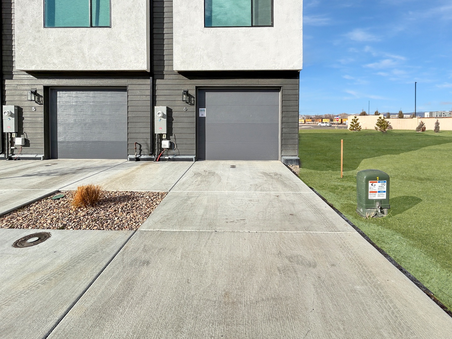 Modern townhome with garage available for guest use and space for one vehicle in driveway.