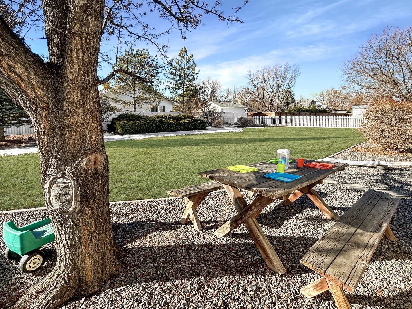 Your private backyard oasis features a rustic picnic table perfect for morning coffee or evening meals under the shade tree.