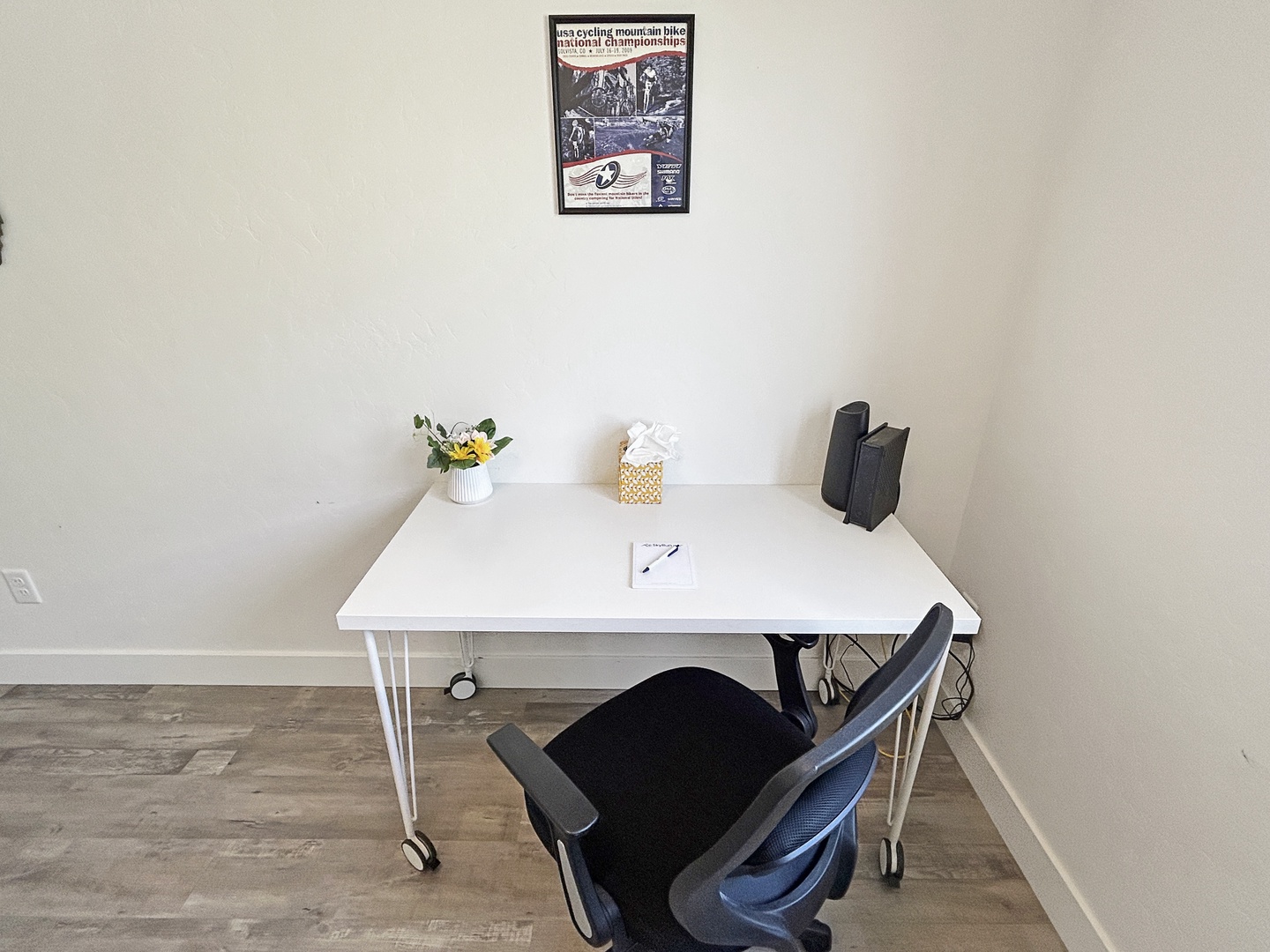 Your dedicated workspace awaits with a clean desk, comfortable chair, and thoughtful touches like fresh flowers to inspire productivity.